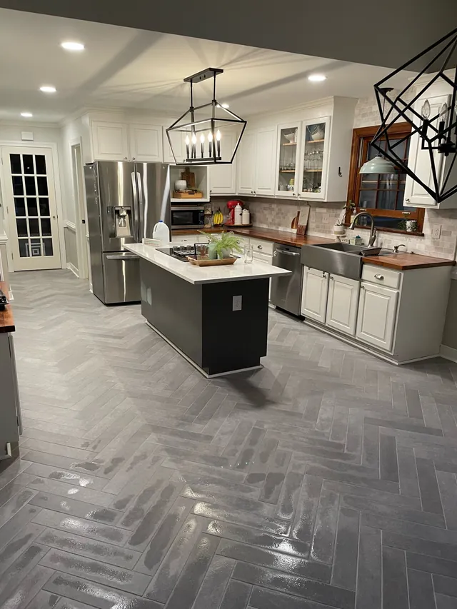 Gray herringbone tile floor running through a kitchen