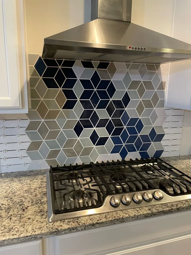 Blue, white and gray diamond tile backsplash behind a range