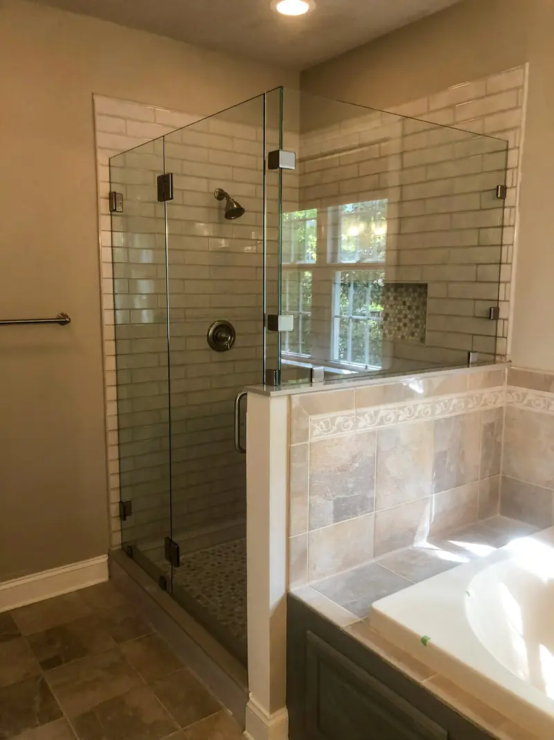 Glass-enclosed shower with a tiled tub deck
