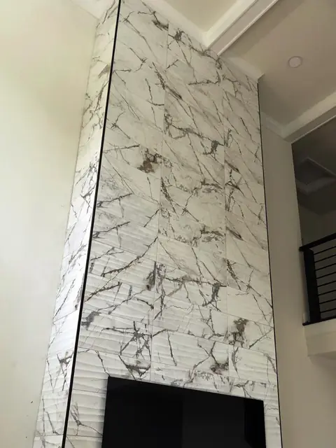 Marble-look tile feature wall above a fireplace opening