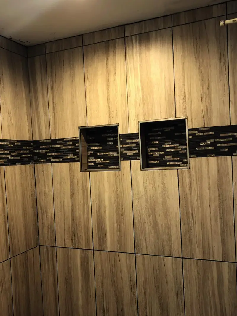 Wood-look tile shower with two niches and a mosaic band