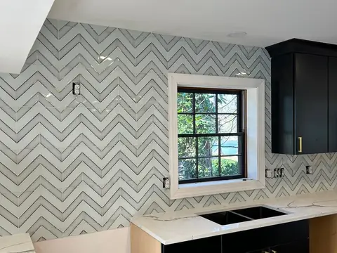 Chevron tile backsplash beside a kitchen window