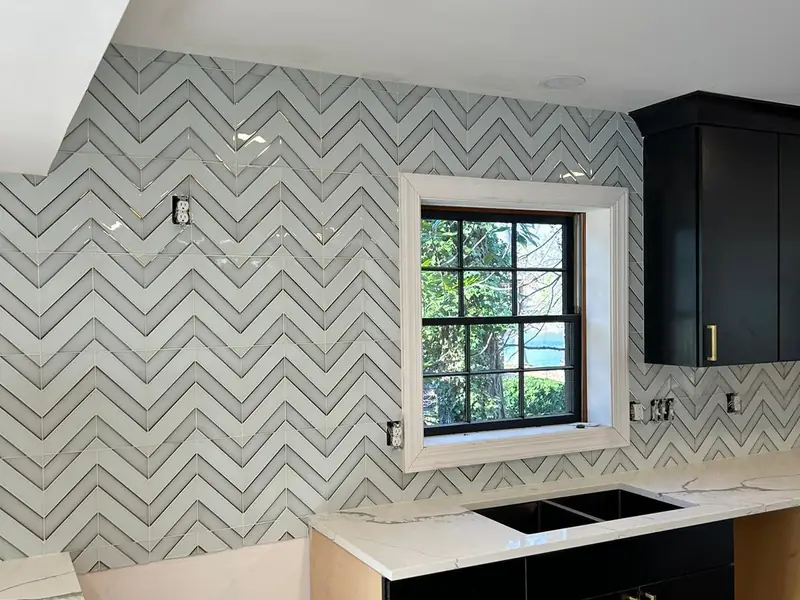 Chevron tile backsplash beside a kitchen window